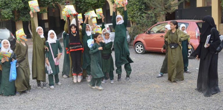 Schoolgirls celebrating with copies of Seyaj magazine
